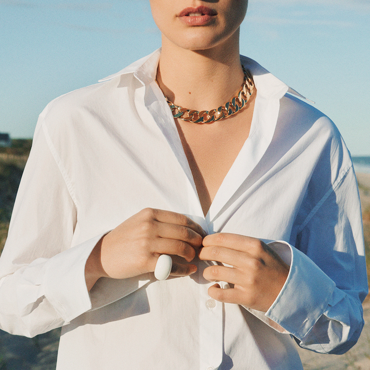 Verdura Curb-Link Necklace worn by a model on the beach