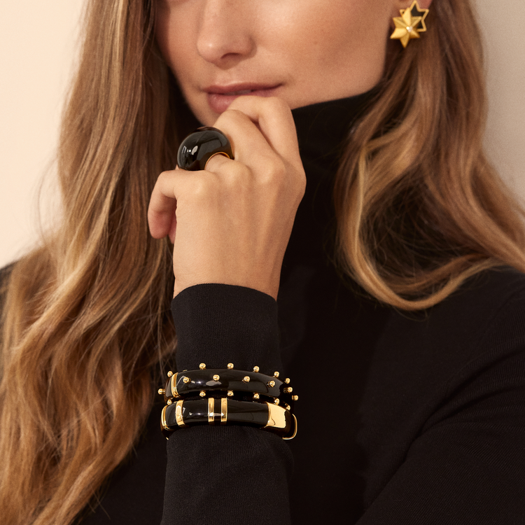 Verdura Copa Ring in Black, Sicily Bangles, and Star Earclips in Black worn by model 